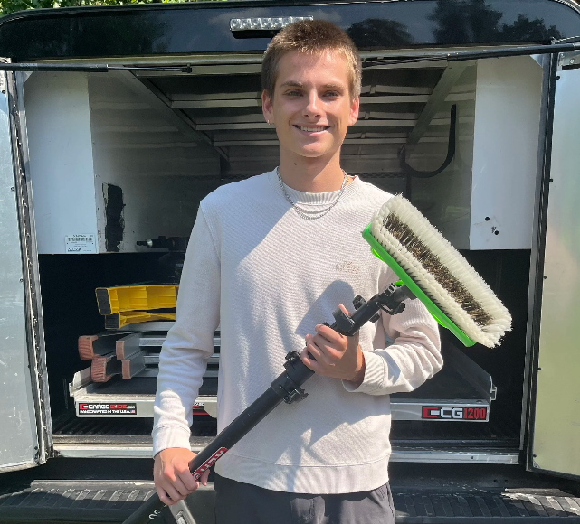 Jackson, founder of CQ Services LLC, holding professional window cleaning equipment